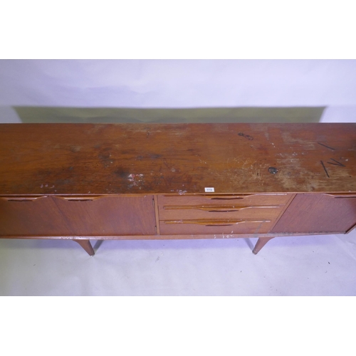 1112 - A mid century teak sideboard with two cupboards flanking three drawers, top AF, 45 x 196 x 75cm