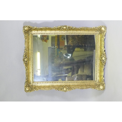 1143 - A gilt composition wall mirror with swept frame, 63 x 79cm