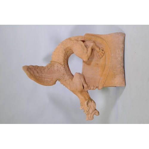 1148 - A terracotta ridge tile in the form of a winged dragon, 68cm high