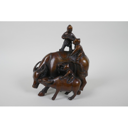 116 - A Chinese filled bronze figure group of children playing on a buffalo, 18cm high