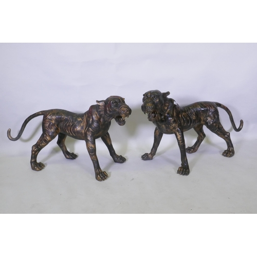 123 - A pair of Chinese bronze life size tiger cubs with the remnants of gilt patina, 114cm long