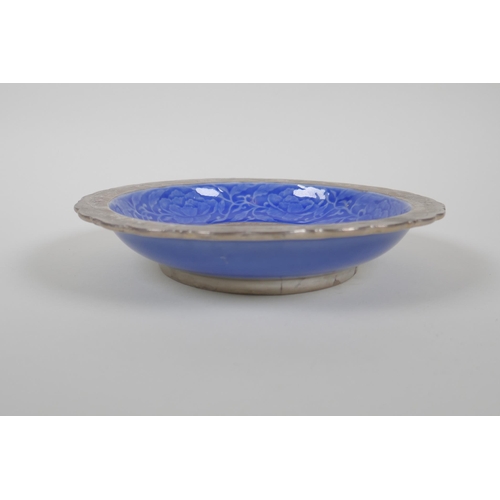 128 - A Chinese blue glazed porcelain dish with a lobed rim and silvered details, decorated with lotus flo... 