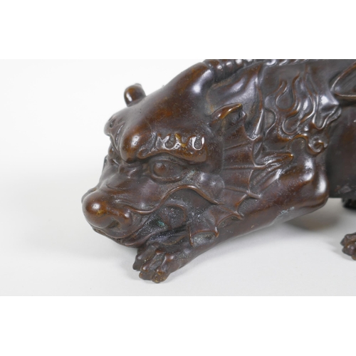 130 - A Chinese filled bronze figure of a winged mythical creature, 20cm long