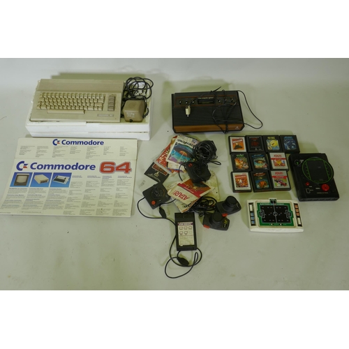 148 - A Commodore 64 personal computer and Atari video game console with joysticks and games