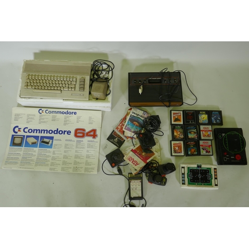 148 - A Commodore 64 personal computer and Atari video game console with joysticks and games