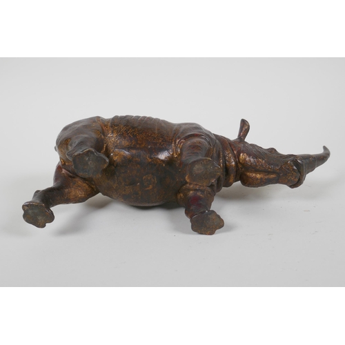 153 - A gilt bronzed metal rhinoceros, filled, 25cm long