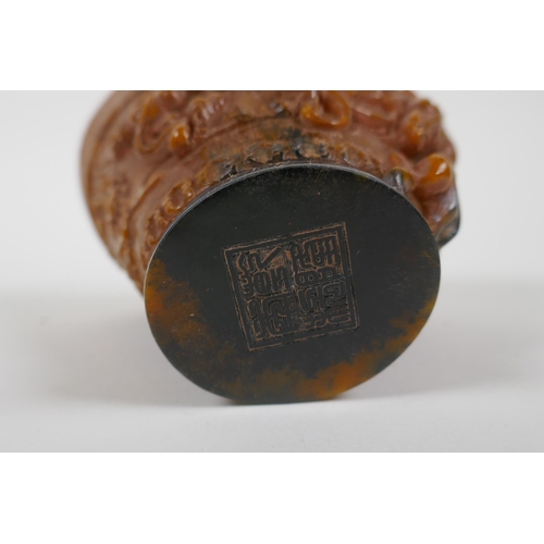 163 - A Chinese faux horn libation cup decorated with kylin and auspicious symbols, seal mark to base, 10c... 