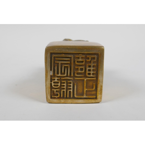 165 - A Chinese filled gilt bronze seal, the knop in the form of kylin inset with coral and turquoise bead... 