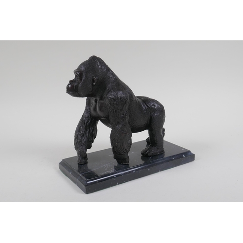 198 - A cast bronzed metal gorilla, mounted on a marble base, 18cm high