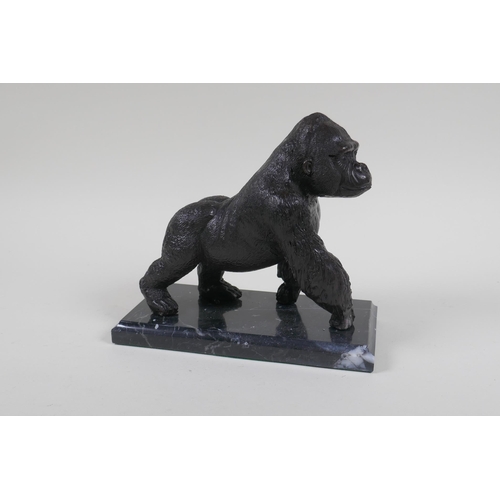 198 - A cast bronzed metal gorilla, mounted on a marble base, 18cm high