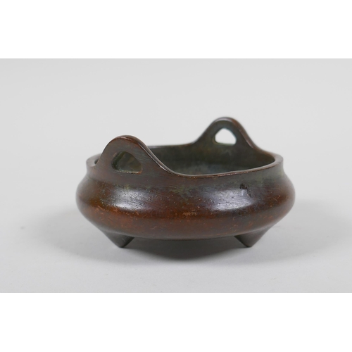 215 - A Chinese bronze censer with phoenix eye handles and tripod supports, impressed mark to base, 9cm di... 