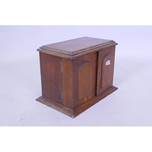 223 - A Victorian golden oak smoker's companion, with two doors opening to reveal a fitted interior with s... 