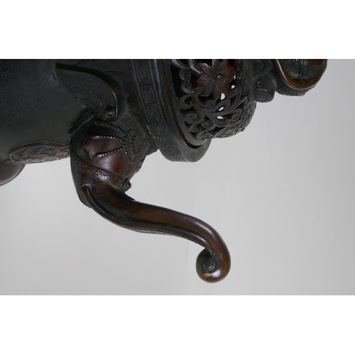 243 - A Chinese bronzed metal two handled censer and pierced cover, raised on elephant head tripod support... 