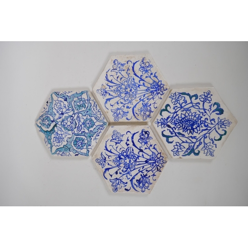 31 - Four Iznik hexagonal pottery tiles decorated with blue and white foliate designs, 14 x 17cm