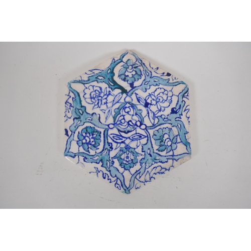 31 - Four Iznik hexagonal pottery tiles decorated with blue and white foliate designs, 14 x 17cm