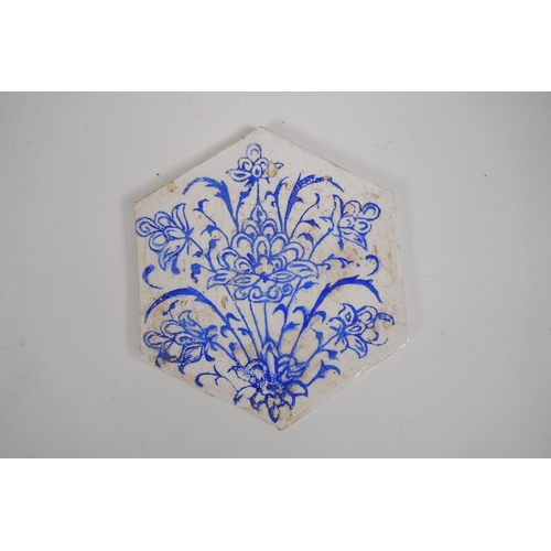 31 - Four Iznik hexagonal pottery tiles decorated with blue and white foliate designs, 14 x 17cm