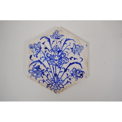 31 - Four Iznik hexagonal pottery tiles decorated with blue and white foliate designs, 14 x 17cm