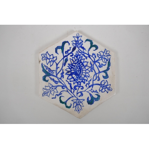 31 - Four Iznik hexagonal pottery tiles decorated with blue and white foliate designs, 14 x 17cm