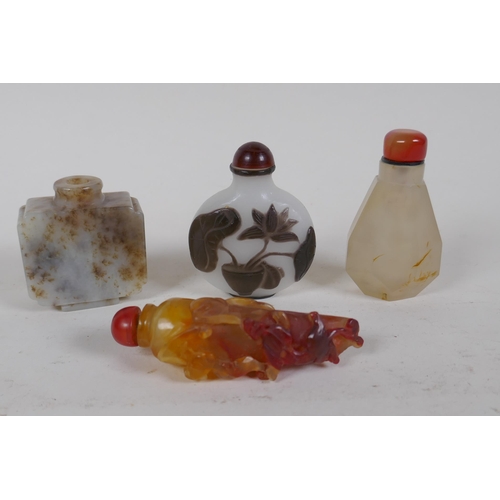 343 - A Peking glass snuff bottle with carved decoration of a potted lotus flower, and a carved hardstone ... 