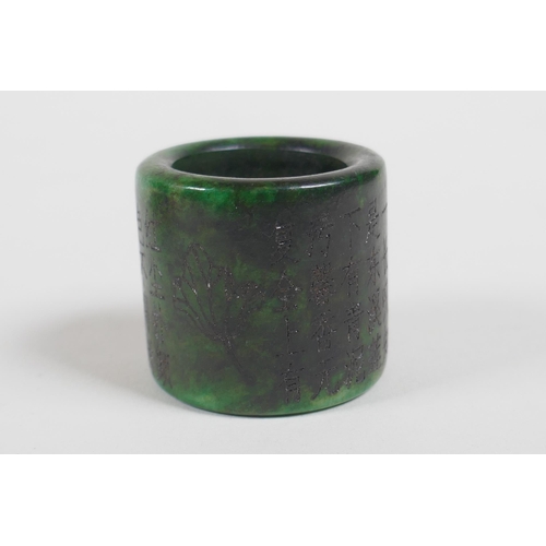 625 - A Chinese carved apple green jade bangle, and a green hardstone archers ring, bangle 7cm diameter