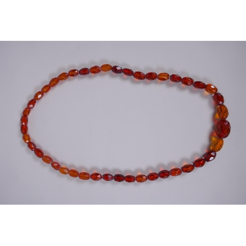 639 - A graduated and faceted honey amber bead necklace, 51cm long, clasp AF