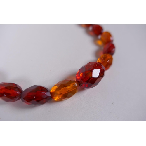 639 - A graduated and faceted honey amber bead necklace, 51cm long, clasp AF