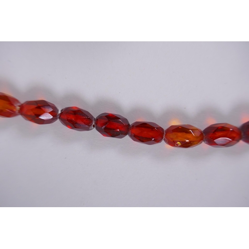 639 - A graduated and faceted honey amber bead necklace, 51cm long, clasp AF