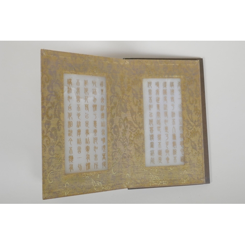 86 - A Chinese wood and silk bound book containing white jade table pages with chased and gilt inscriptio... 