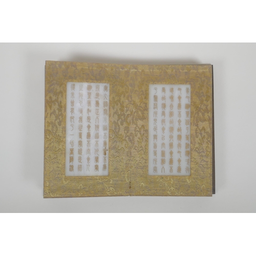 86 - A Chinese wood and silk bound book containing white jade table pages with chased and gilt inscriptio... 