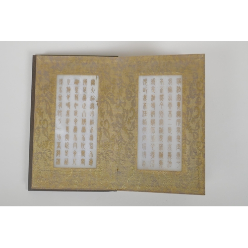 86 - A Chinese wood and silk bound book containing white jade table pages with chased and gilt inscriptio... 