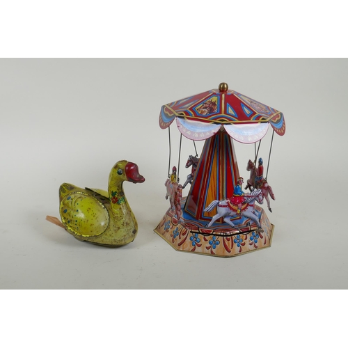 99 - A vintage Chinese Gosling Goose clockwork tin toy, and a later German tin plate Merry-Go-Round, larg... 