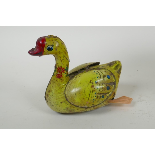 99 - A vintage Chinese Gosling Goose clockwork tin toy, and a later German tin plate Merry-Go-Round, larg... 