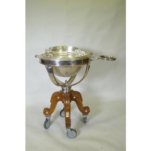 611 - A silver plated revolving meat carving trolley with roll top cover raised on a wood base with castor... 