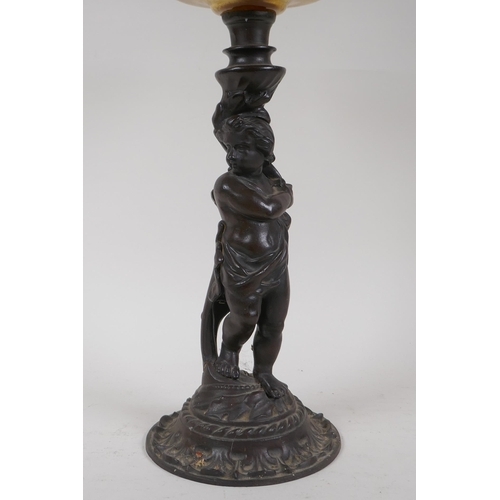 3 - An early C20th oil lamp with cast iron base in the form of a putto, 47cm high