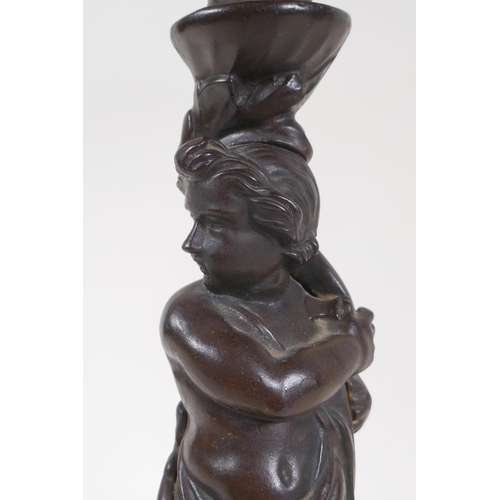 3 - An early C20th oil lamp with cast iron base in the form of a putto, 47cm high