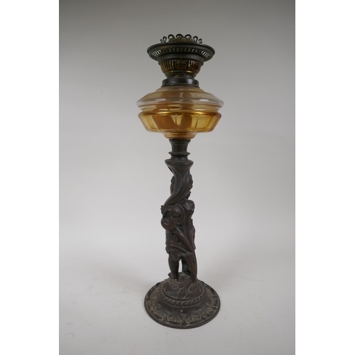 3 - An early C20th oil lamp with cast iron base in the form of a putto, 47cm high