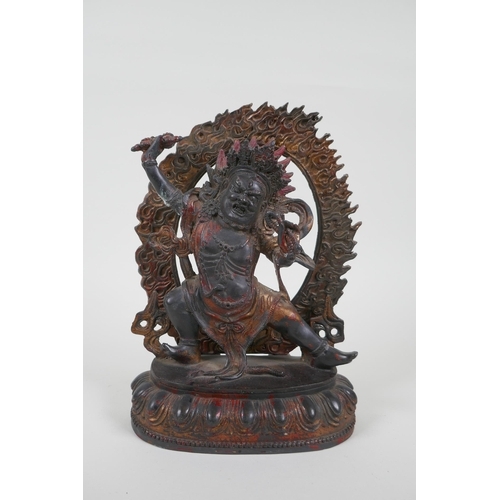 37 - A Tibetan bronze figure of a wrathful deity, with the remnants of gilt patina, 24cm high