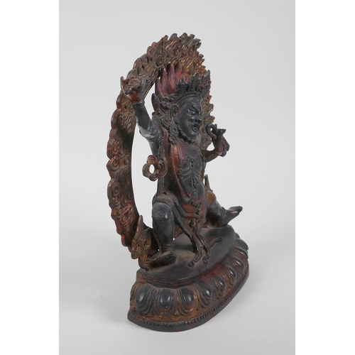 37 - A Tibetan bronze figure of a wrathful deity, with the remnants of gilt patina, 24cm high