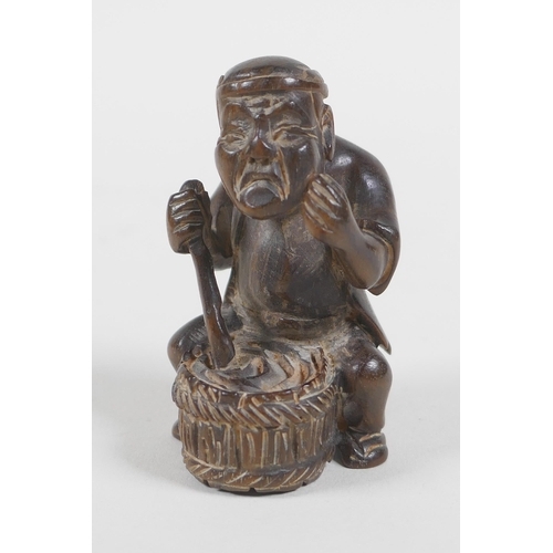 57 - A Japanese carved wood netsuke in the form of a man making mochi, 5cm high