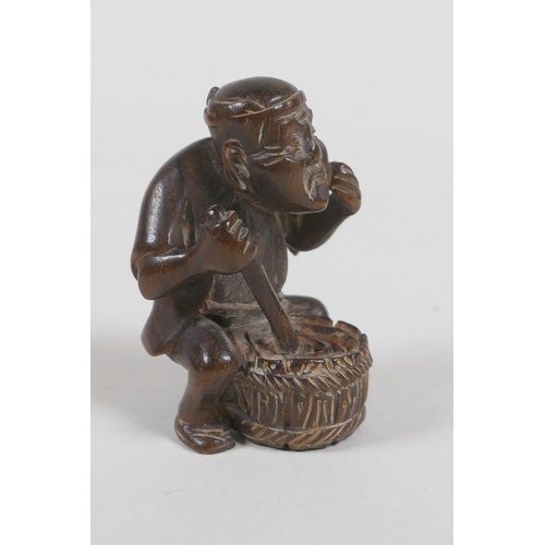 57 - A Japanese carved wood netsuke in the form of a man making mochi, 5cm high