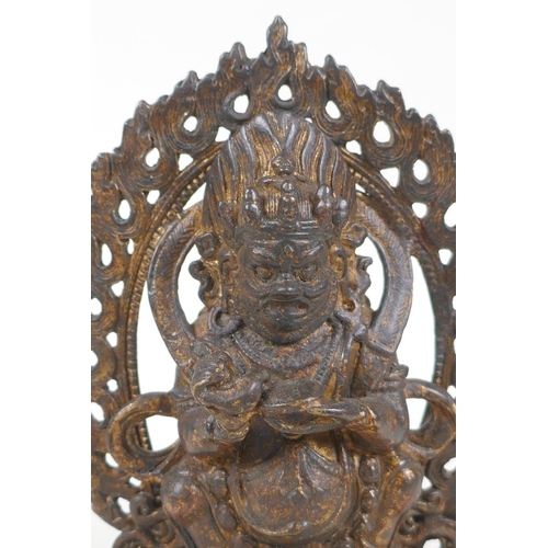 67 - A Tibetan gilt bronze figure of a wrathful deity, impressed double vajra mark to base, 17cm high