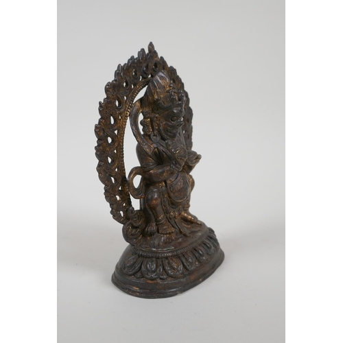 67 - A Tibetan gilt bronze figure of a wrathful deity, impressed double vajra mark to base, 17cm high