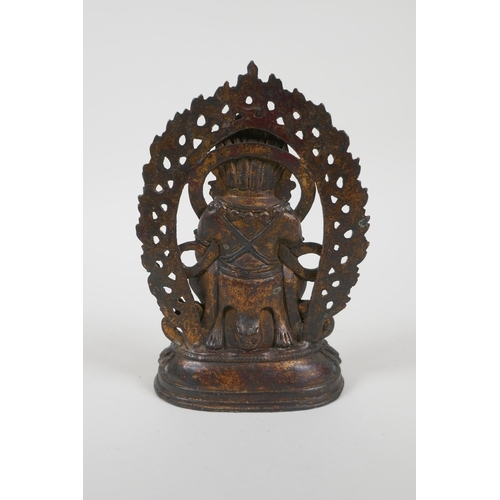 67 - A Tibetan gilt bronze figure of a wrathful deity, impressed double vajra mark to base, 17cm high