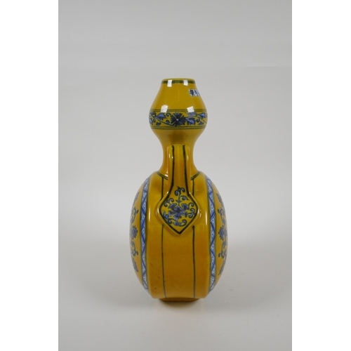 80 - A Chinese yellow ground porcelain moon flask with garlic head shaped neck, two handles and blue and ... 