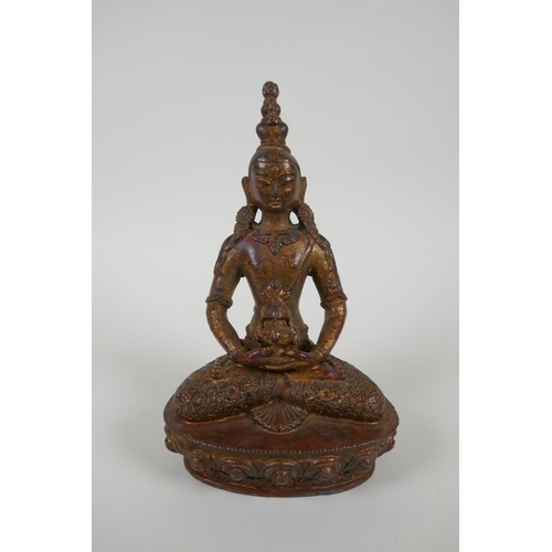 131 - A Tibetan gilt bronze figure of Buddha holding a stupa, 20cm long