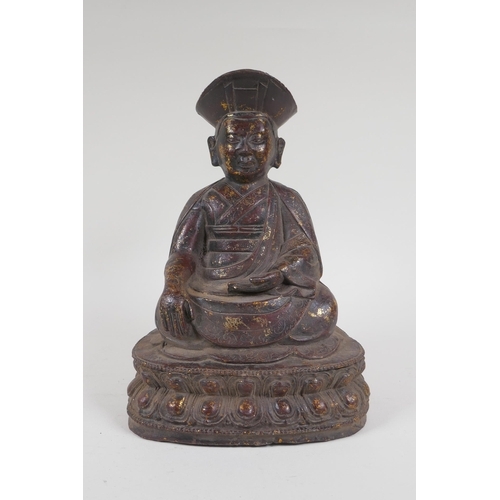 142 - A Chinese bronze figure of a priest seated in meditation, with the remnants of gilt patina, 24cm hig... 