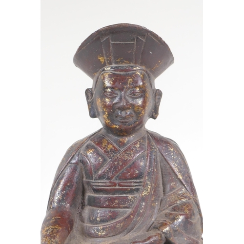 142 - A Chinese bronze figure of a priest seated in meditation, with the remnants of gilt patina, 24cm hig... 