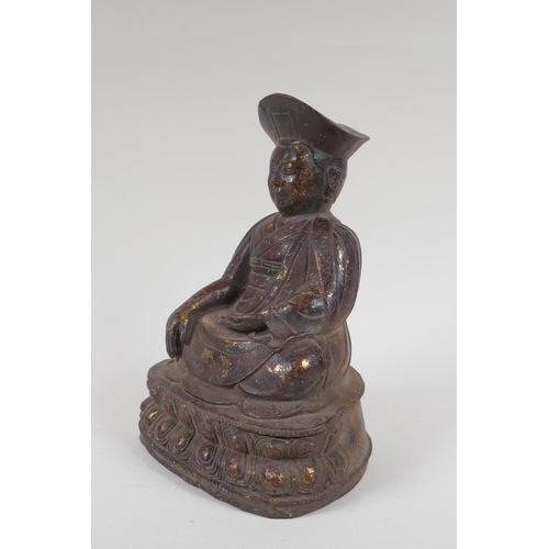 142 - A Chinese bronze figure of a priest seated in meditation, with the remnants of gilt patina, 24cm hig... 