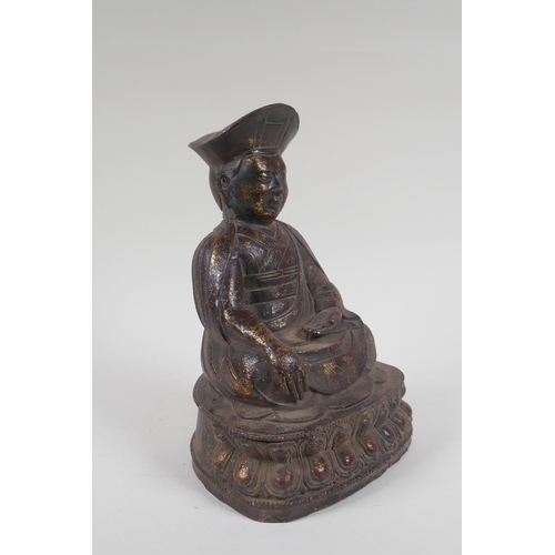 142 - A Chinese bronze figure of a priest seated in meditation, with the remnants of gilt patina, 24cm hig... 