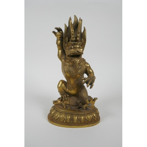 144 - A Tibetan bronze of a wrathful beast seated on a pig, double vajra mark to base, 22cm high